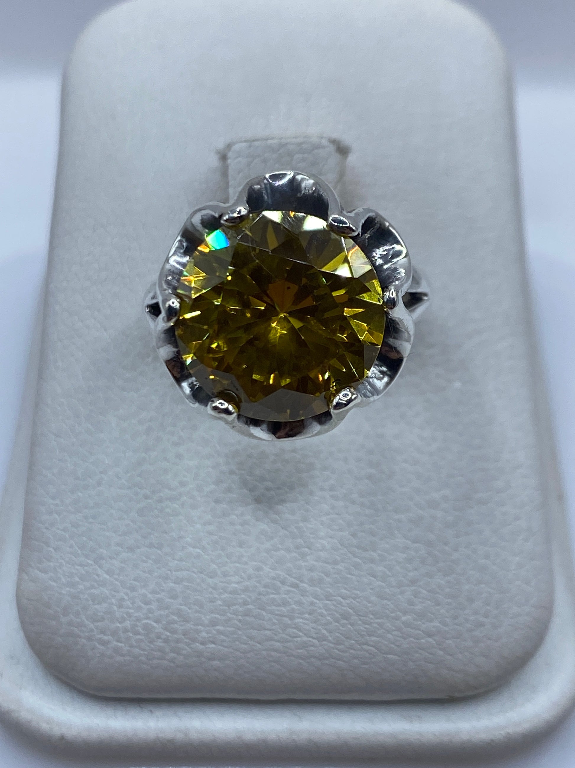 Anillo de plata solitario con circonia amarilla brillante, vista superior sobre fondo blanco