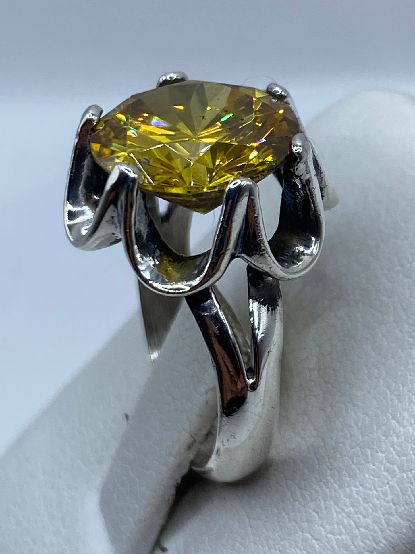 Anillo solitario de plata pura en dedo, mostrando el brillo radiante de la circonia
