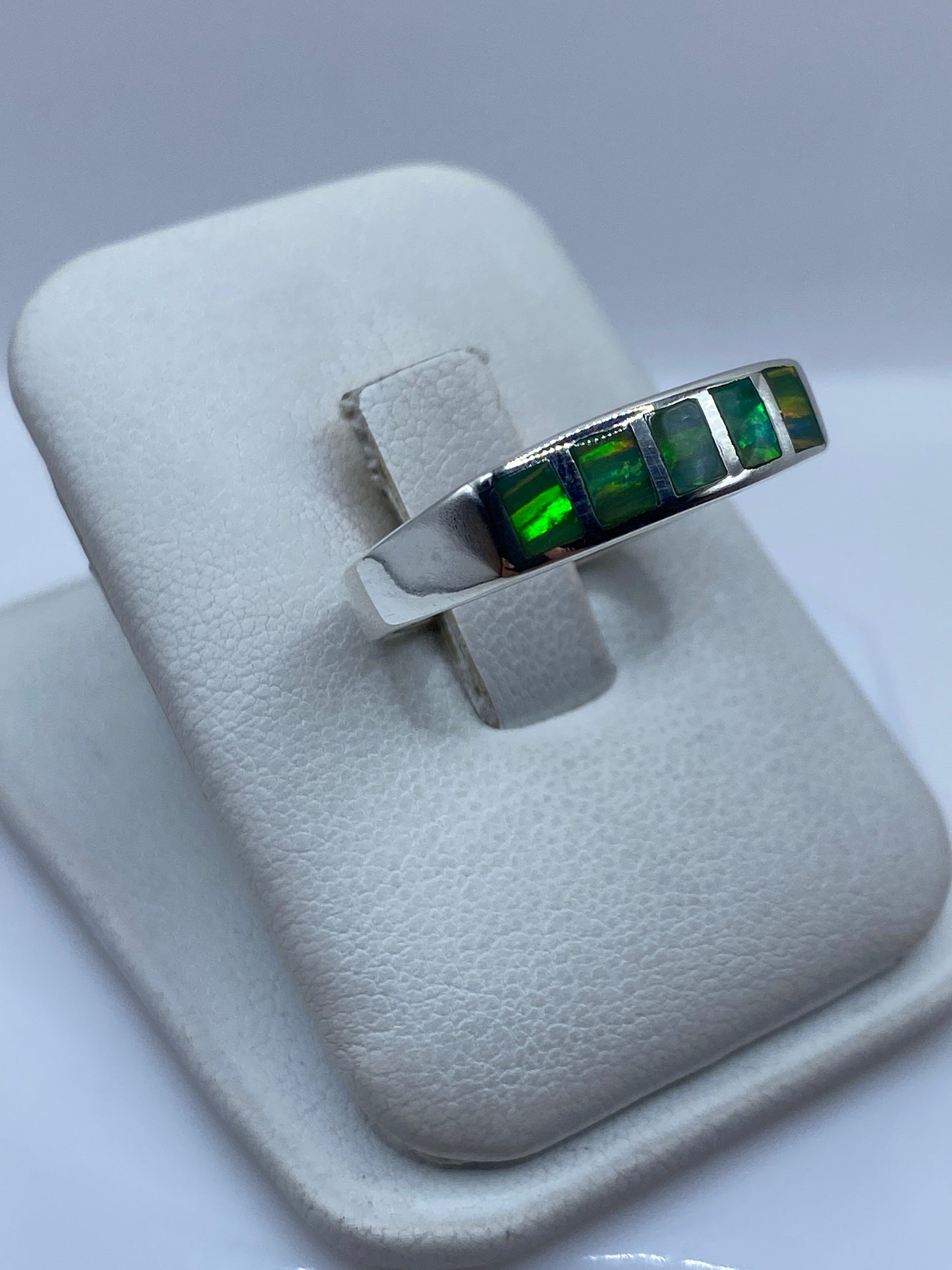 Detalle del engaste a mano de los ópalos de fuego en plata .950 con tonos verde y amarillo