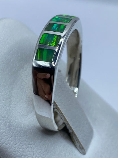 Anillo en mano mostrando los juegos de luz en los ópalos de fuego