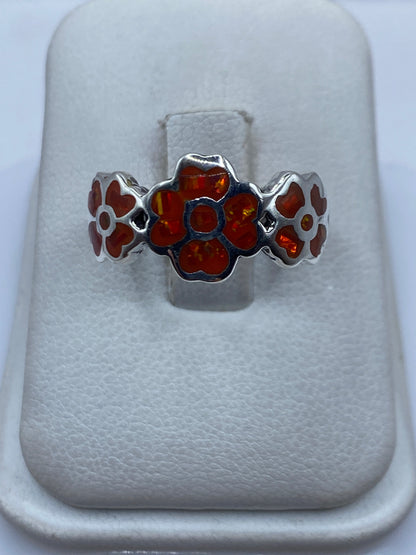 Anillo de plata .925 con ópalo de fuego naranja en la mano de una mujer