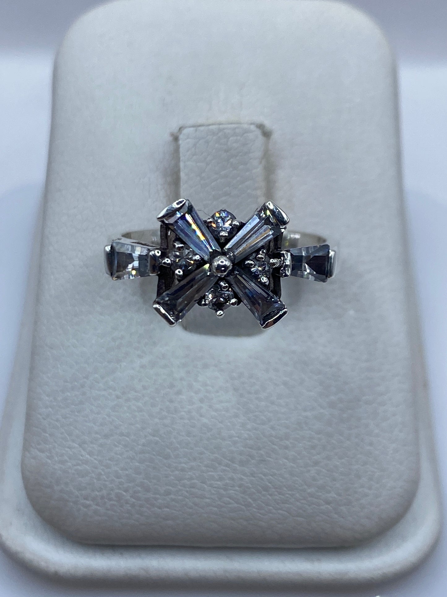 Anillo de plata .925 con circonia blanca engastada en diseño de cruz geométrico sobre soporte blanco