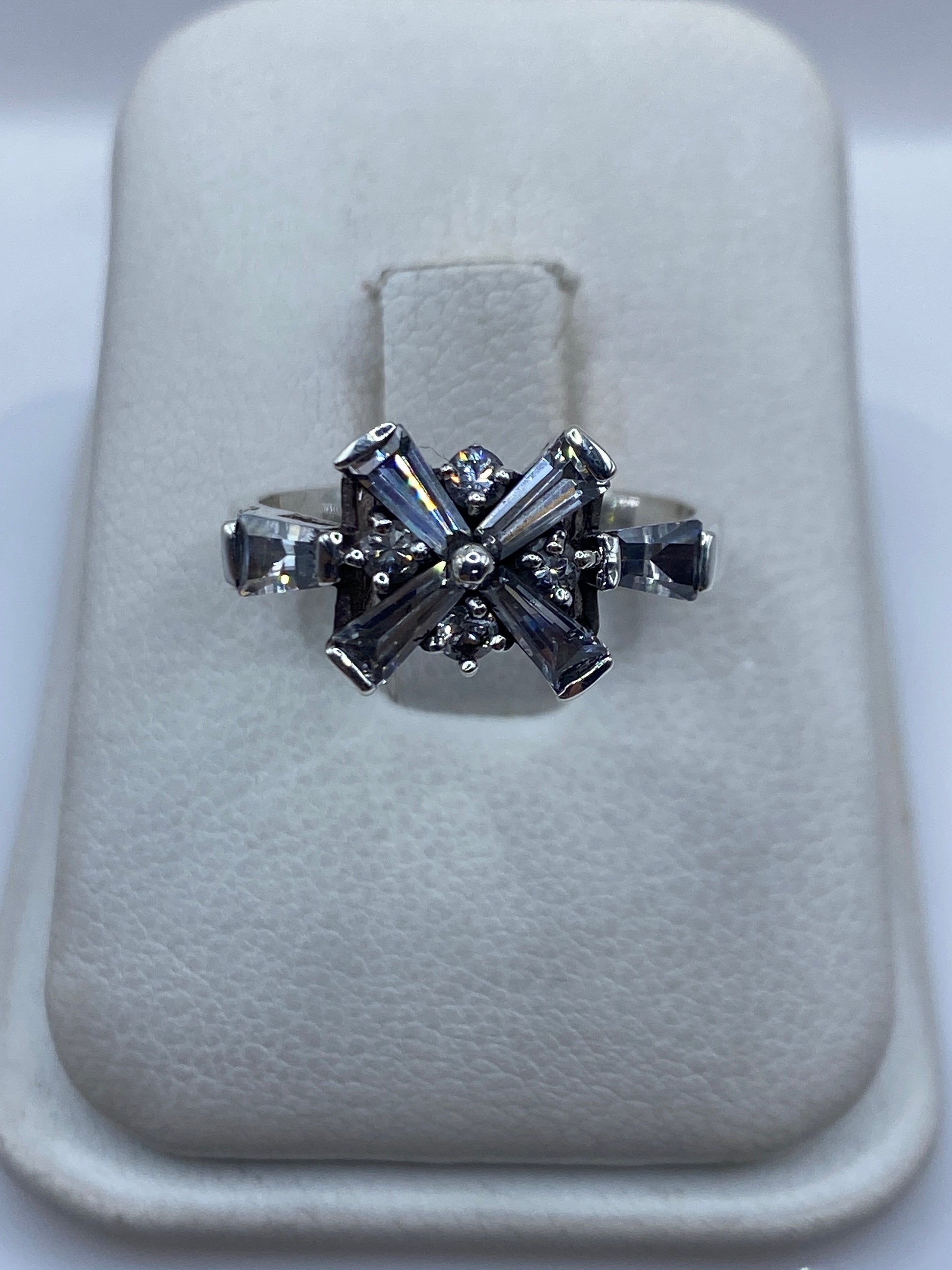 Anillo de plata .925 con circonia blanca engastada en diseño de cruz geométrico sobre soporte blanco