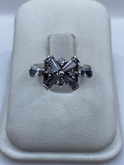 Anillo de plata .925 con circonia blanca engastada en diseño de cruz geométrico sobre soporte blanco