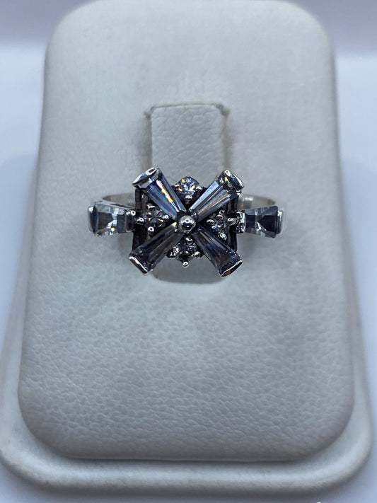 Anillo de plata .925 con circonia blanca engastada en diseño de cruz geométrico sobre soporte blanco