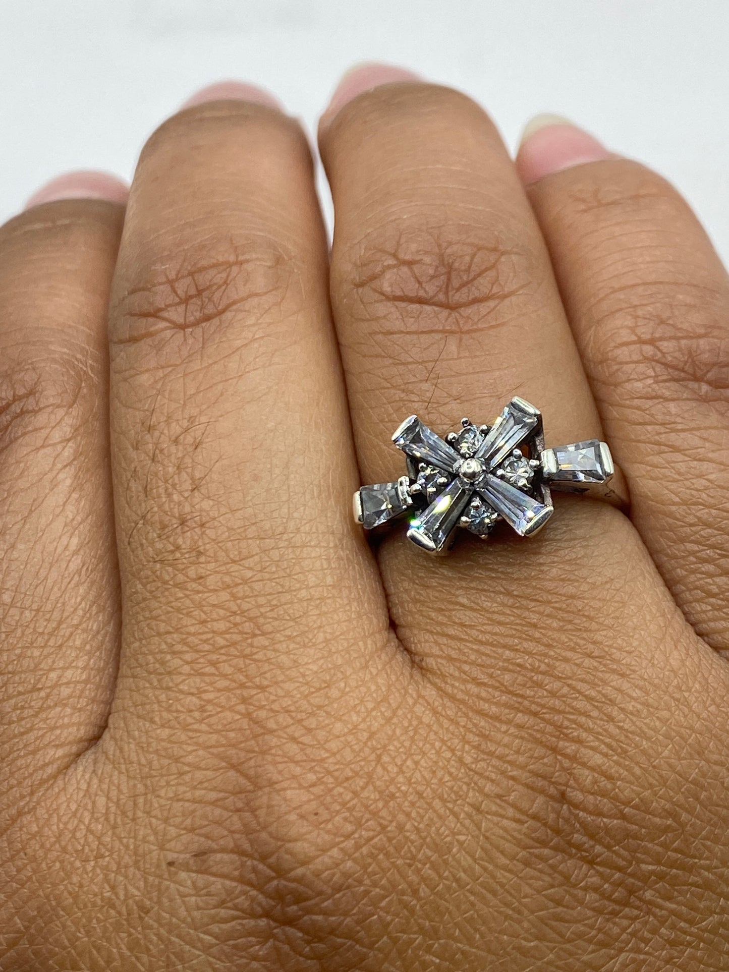 Anillo en dedo mostrando el brillo de las circonias y la plata pulida de Taxco