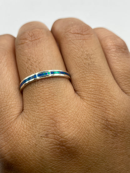 Anillo en dedo mostrando el juego de luz del ópalo azul en tonos naturales