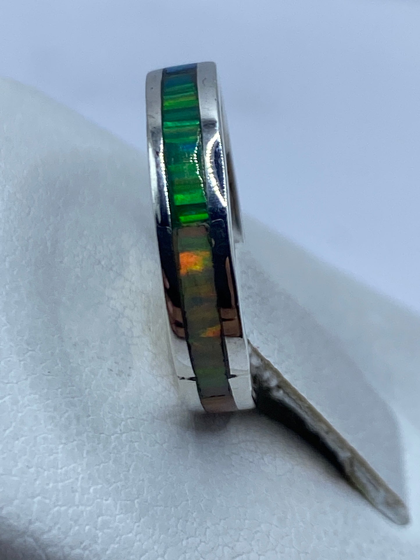 Anillo en la mano mostrando el brillo multicolor del ópalo