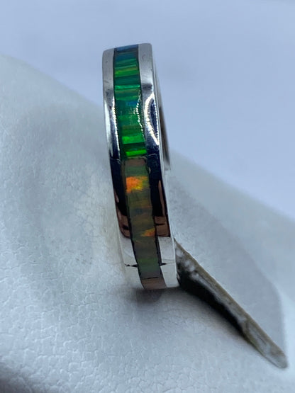 Anillo en la mano mostrando el brillo multicolor del ópalo