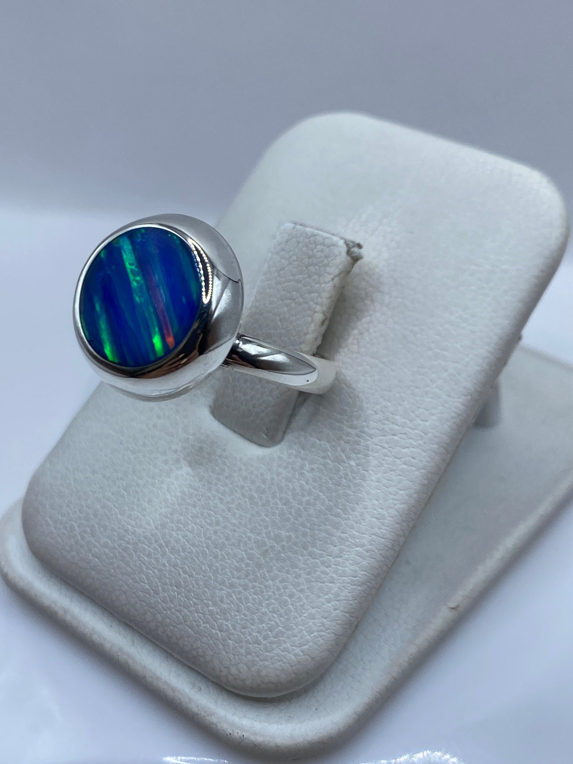 Detalle del ópalo de fuego engastado en plata .925 mostrando tonos azul y verde