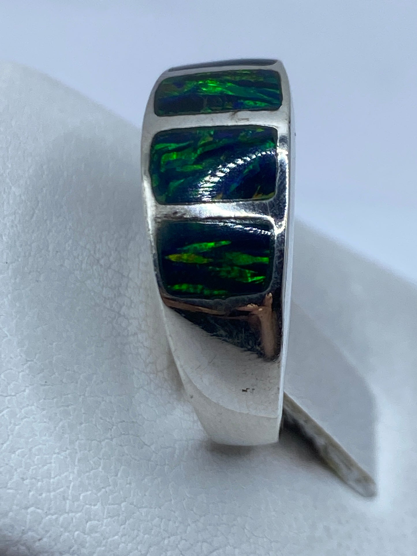 Anillo puesto en dedo mostrando los detalles del engaste a mano del ópalo verde