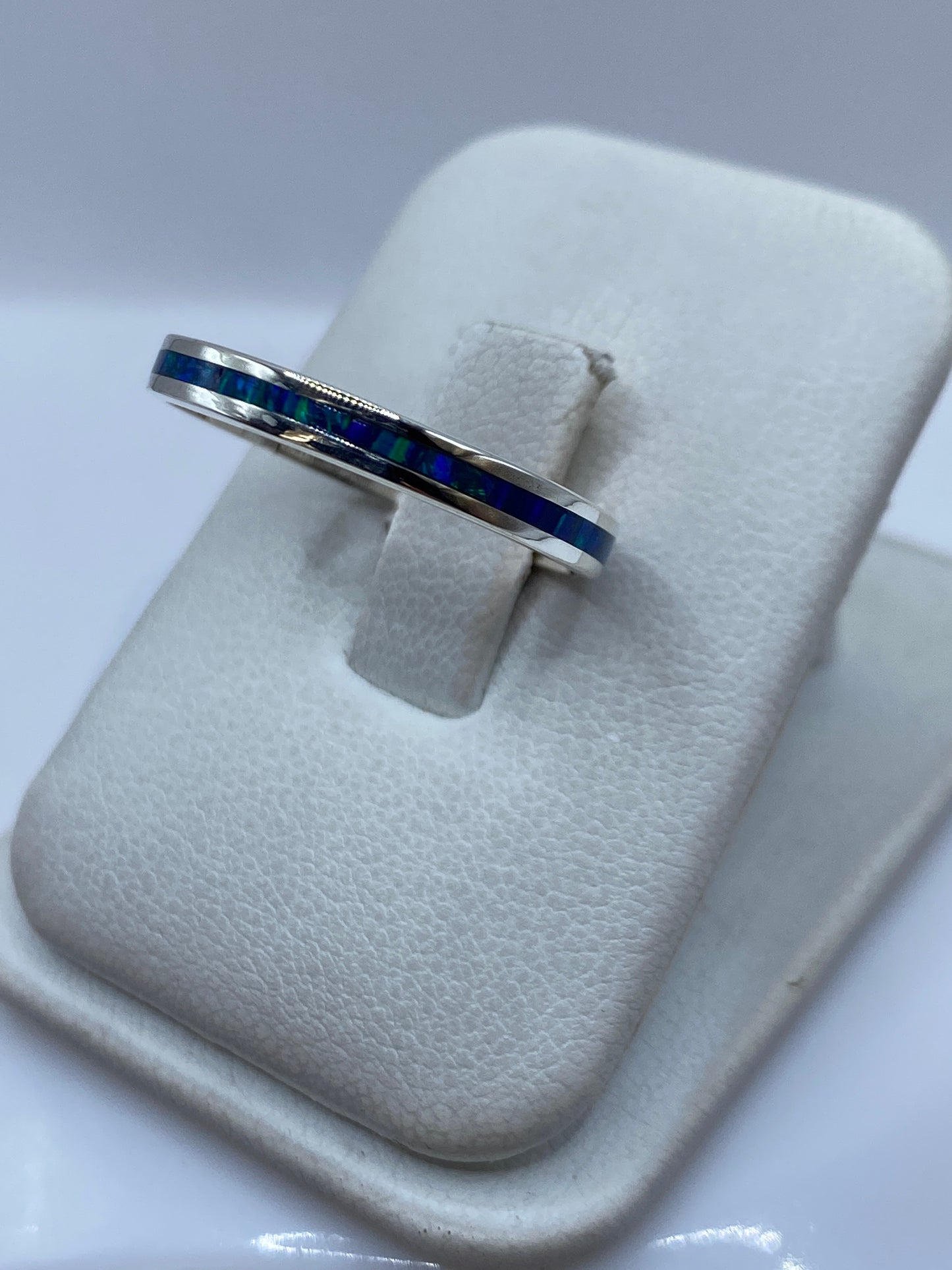 Anillo unisex con ópalo de fuego azul, vista lateral mostrando el engaste