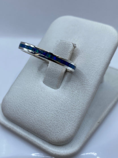 Anillo unisex con ópalo de fuego azul, vista lateral mostrando el engaste