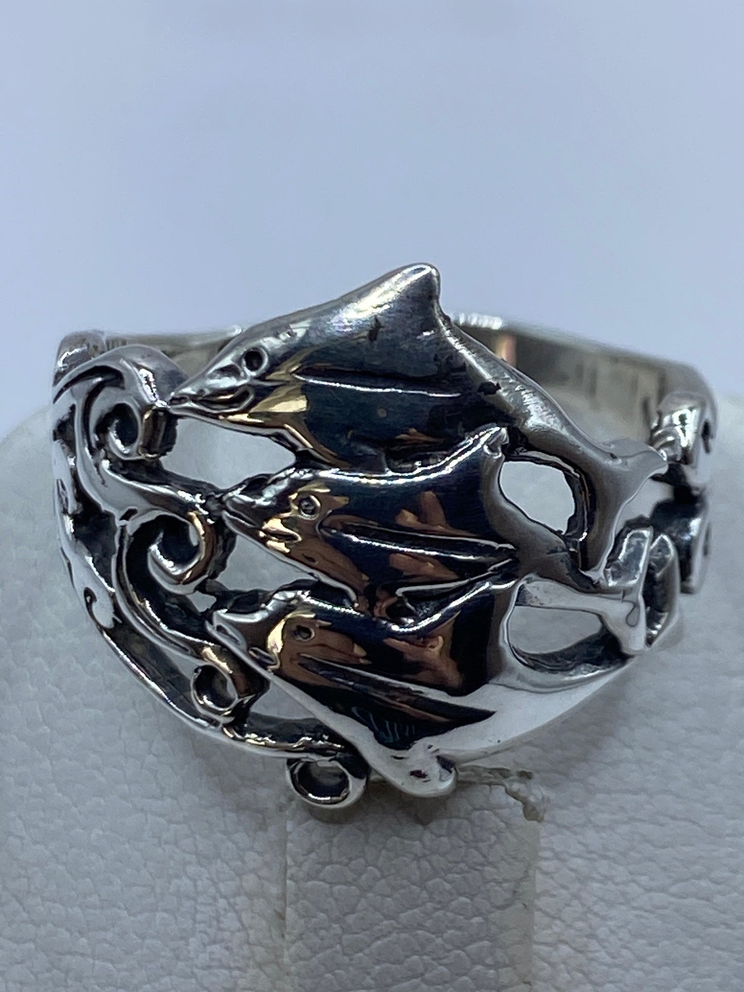 Anillo de plata calado en la mano de una mujer, mostrando el diseño abierto y elegante