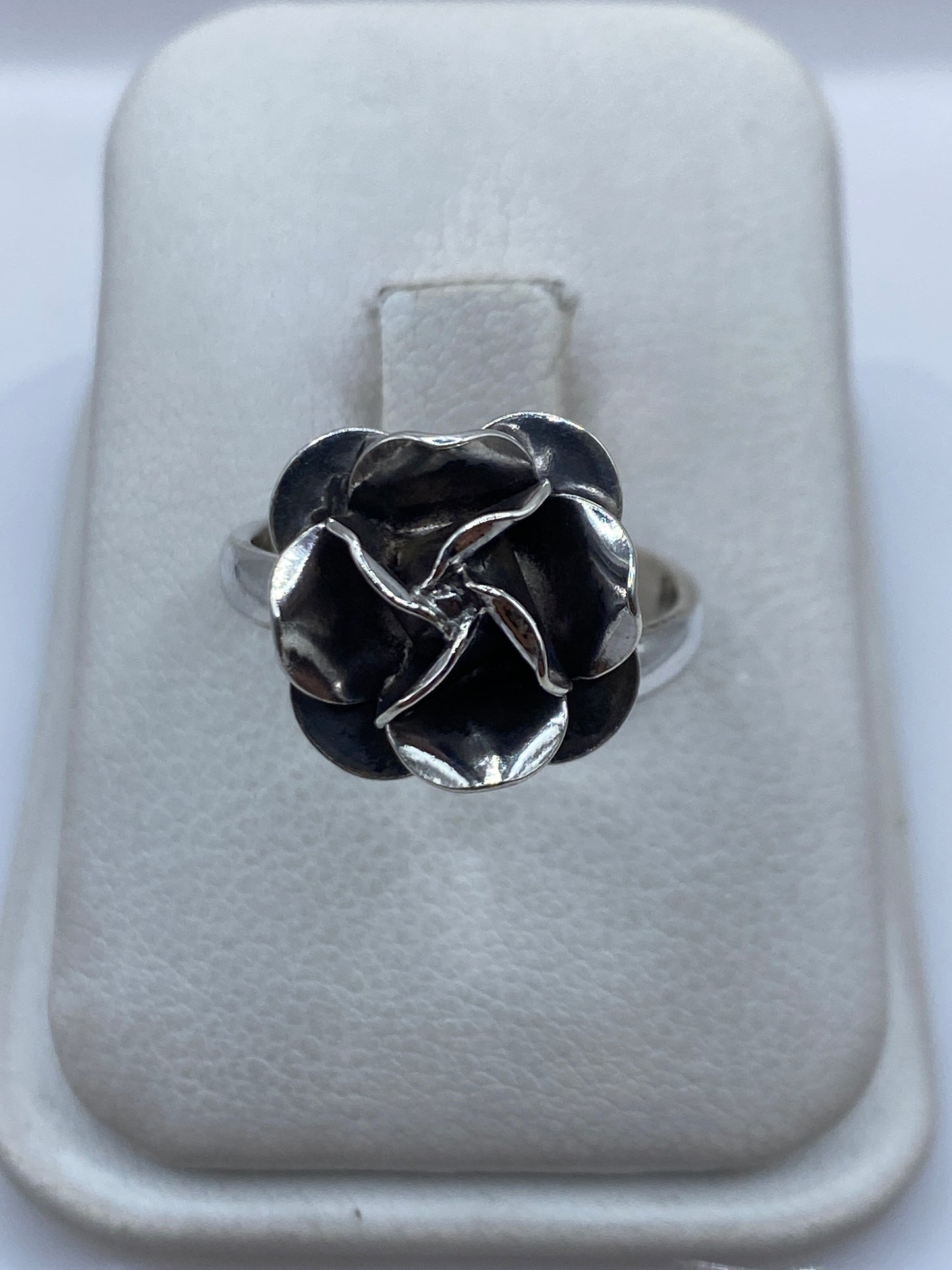 Anillo ajustable de plata con diseño de rosa en relieve sobre estuche blanco
