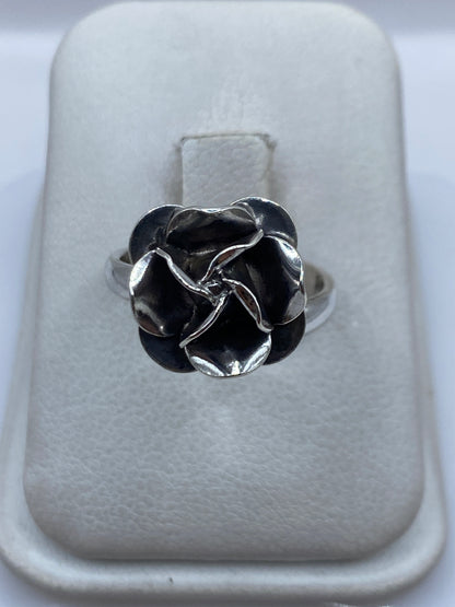 Anillo ajustable de plata con diseño de rosa en relieve sobre estuche blanco
