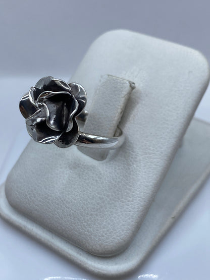 Vista lateral del anillo ajustable rosa mostrando los pétalos en detalle