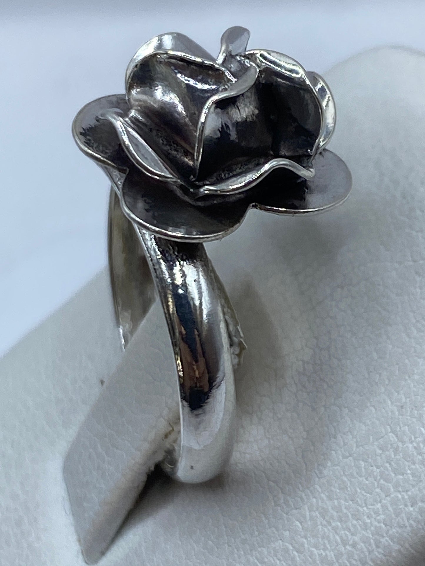 Anillo en la mano de una mujer luciendo el diseño floral pulido