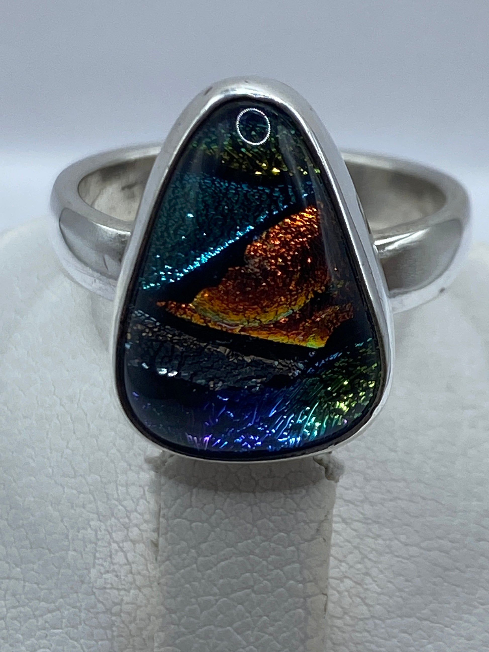 Anillo de plata en la mano mostrando el multicolor de la piedra bajo luz natural
