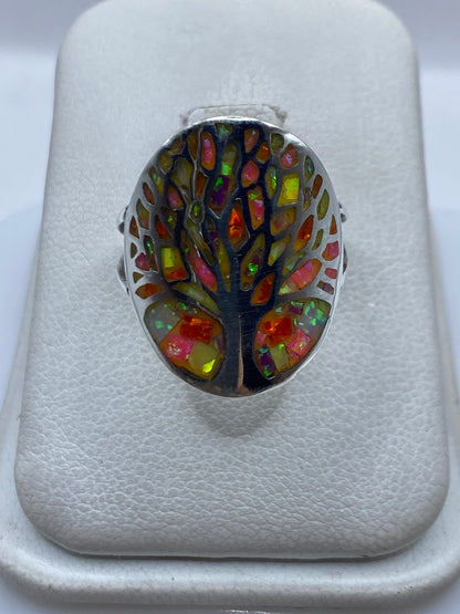 Anillo de plata con ópalo de fuego multicolor sobre fondo blanco