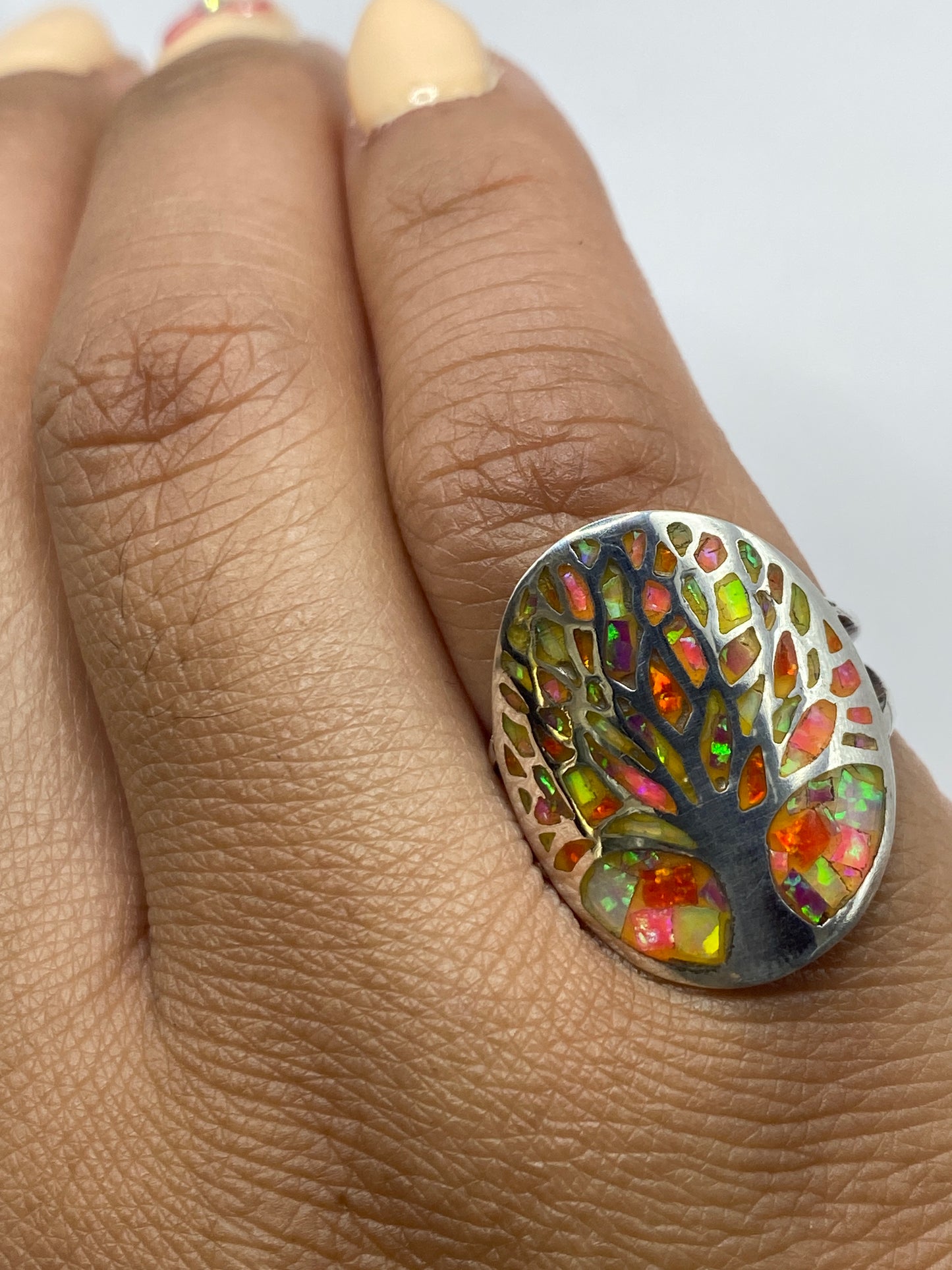 Anillo en la mano mostrando el brillo multicolor del ópalo de fuego