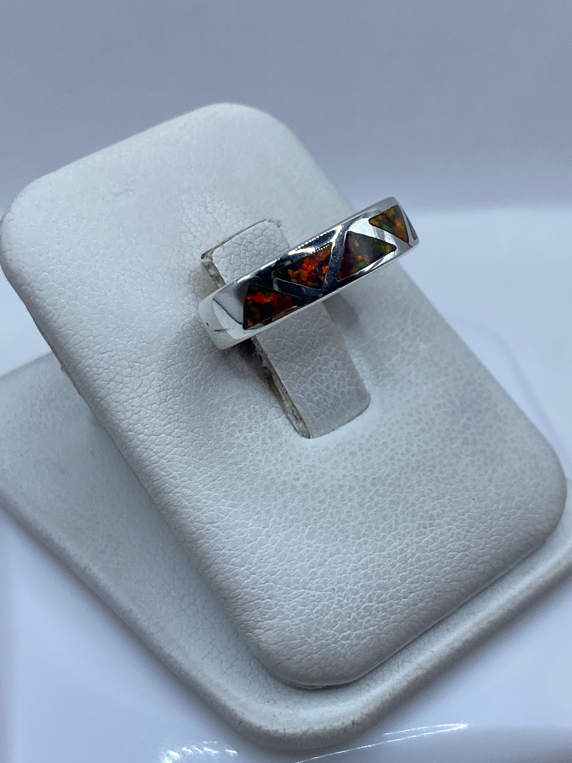 Detalle lateral del anillo de plata mostrando el engaste a mano del ópalo multicolor