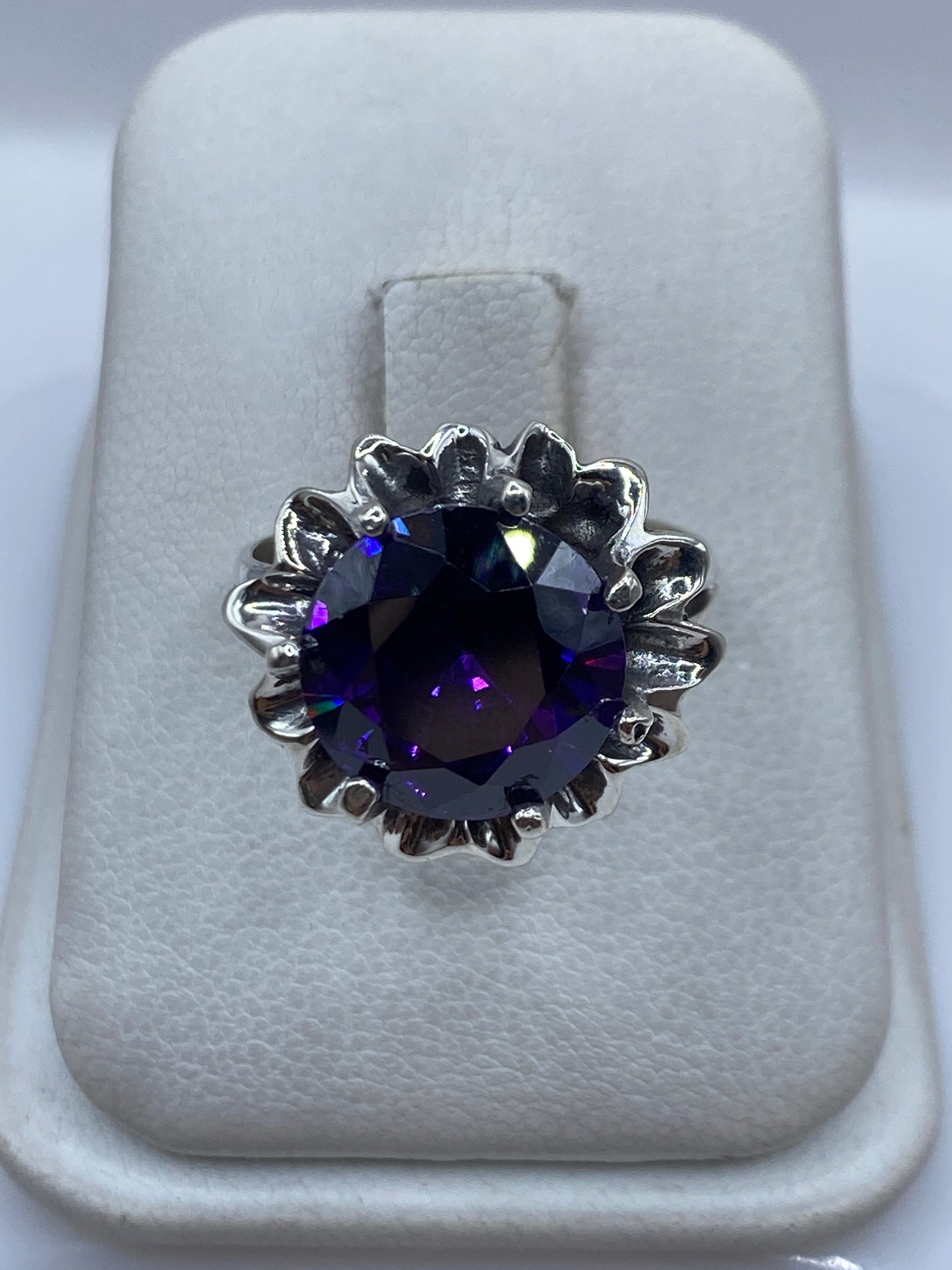 Anillo de plata con circonia morada en corona floral, vista frontal en estuche