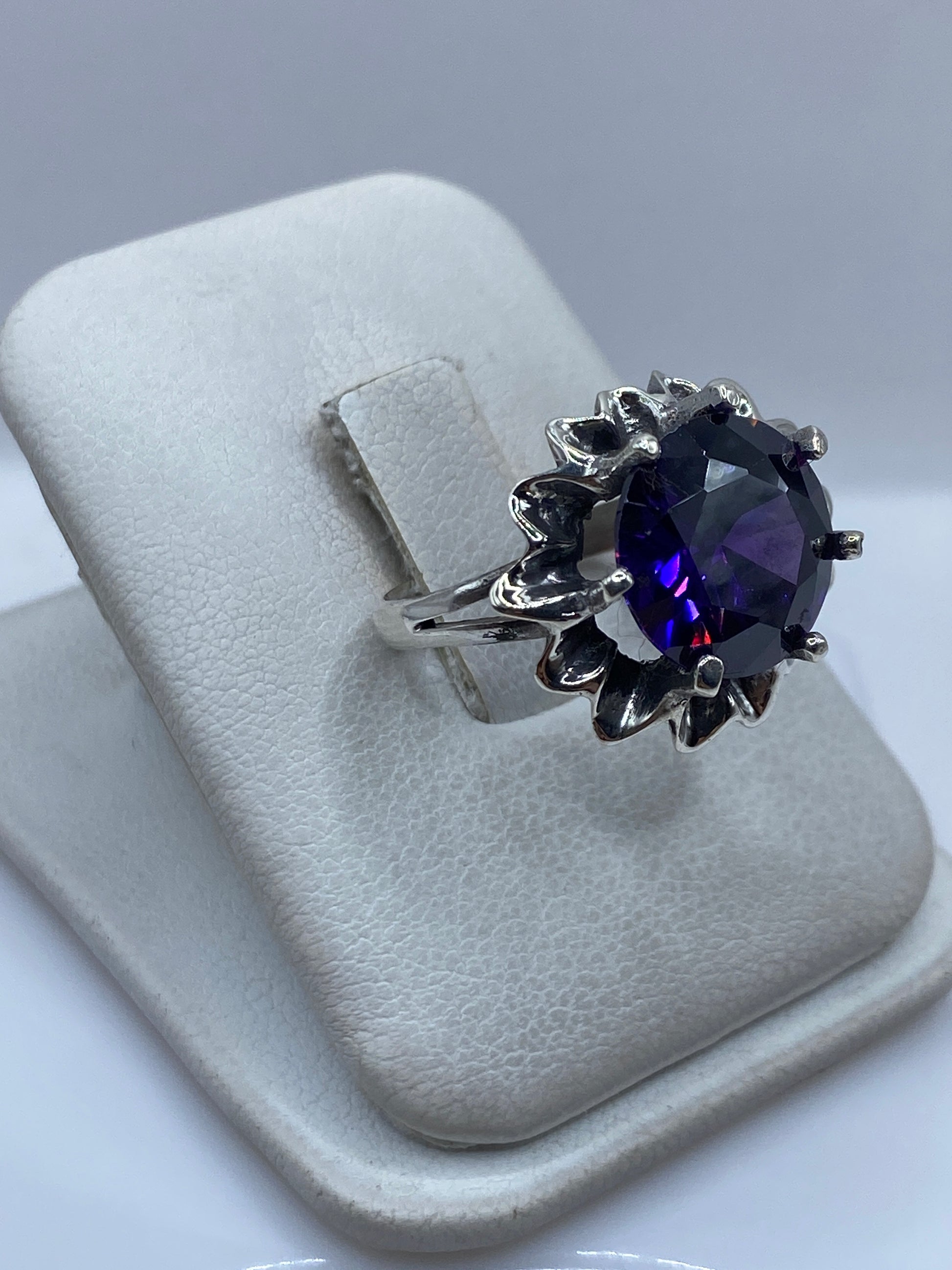 Anillo vintage de circonia morada en dedo, luz natural mostrando el brillo