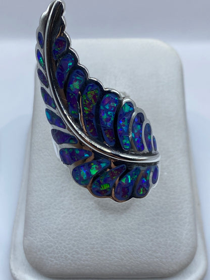 Anillo de plata .950 con ópalo de fuego morado en forma de ala sobre banda texturizada
