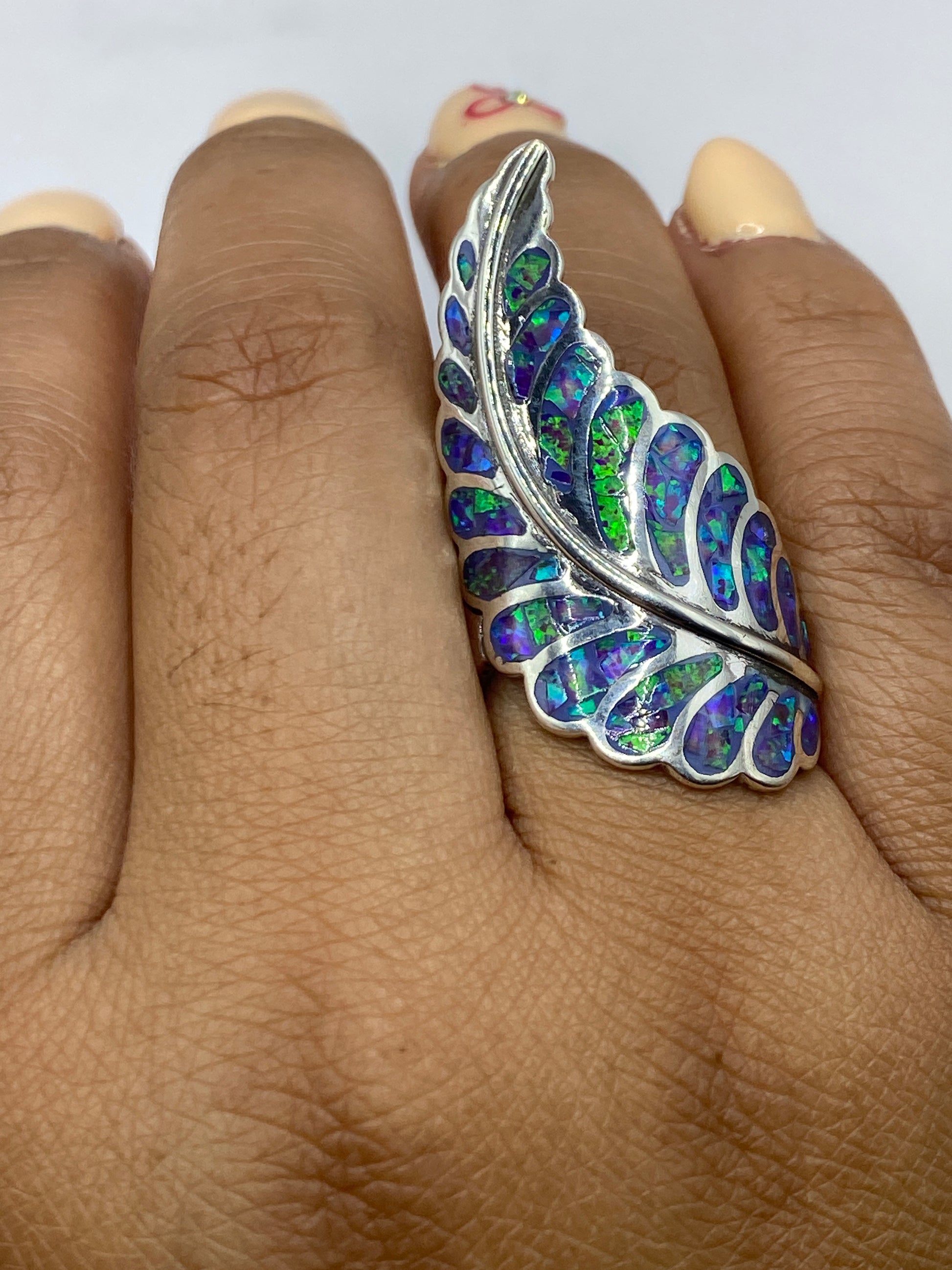 Anillo sobre dedo mostrando cómo brilla el ópalo con la luz natural