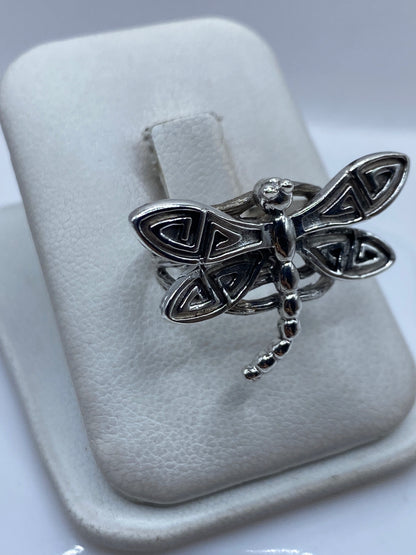 Detalle frontal del anillo libélula mostrando el cuerpo pulido y los patrones triangulares de las alas