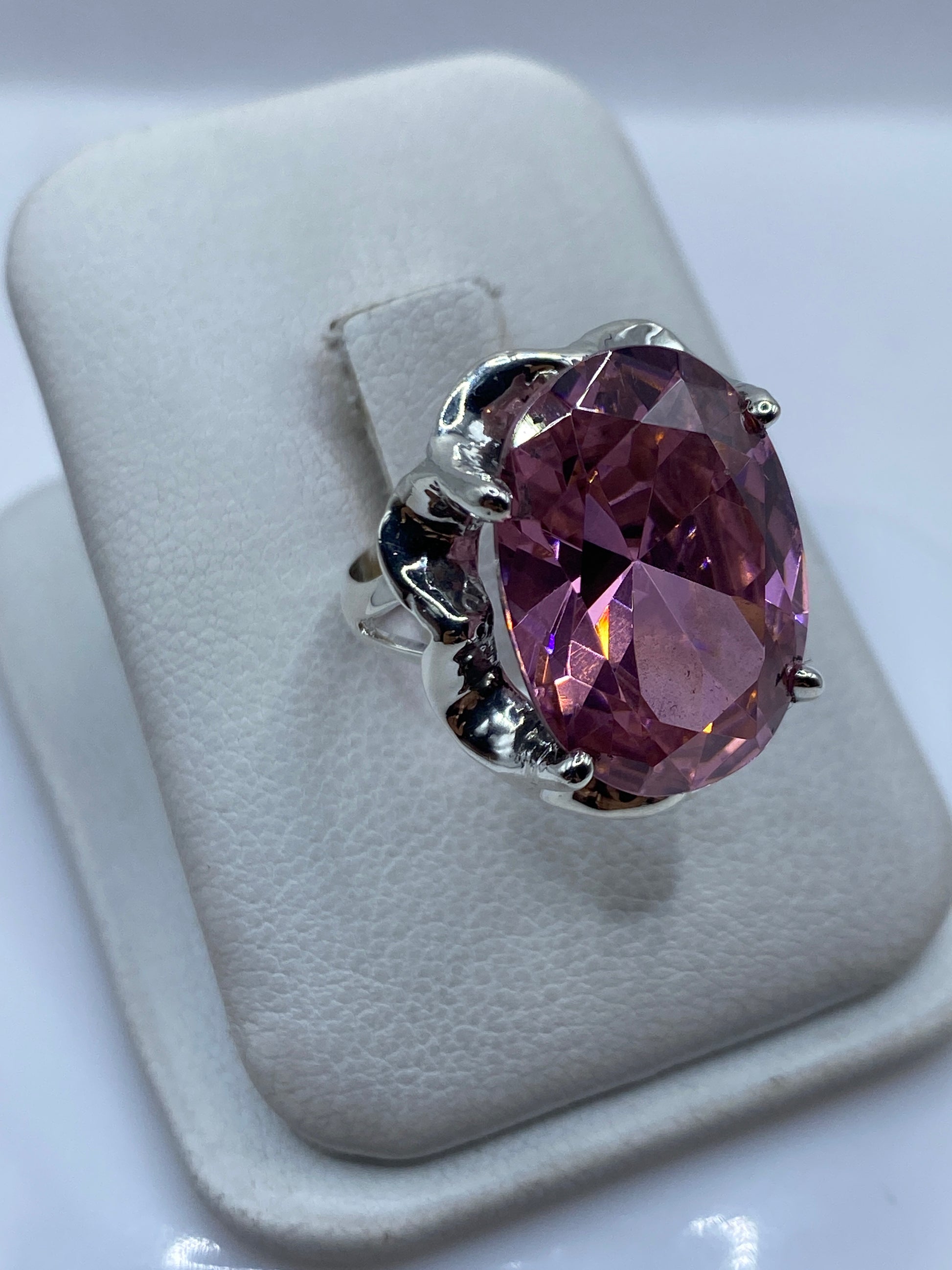 Detalle del engaste a mano: los prongs de plata .925 rodeando la circonia rosa