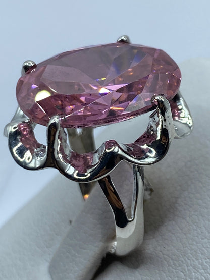 Anillo puesto en mano de mujer, mostrando el brillo de la circonia rosa bajo luz natural