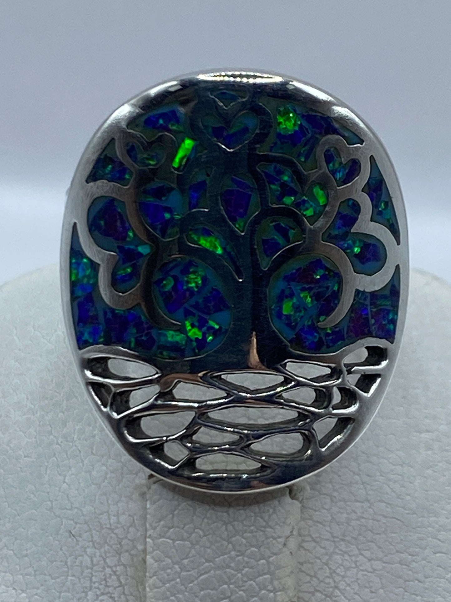 Anillo en mano mostrando el diseño calado artesanal y el engaste de la piedra