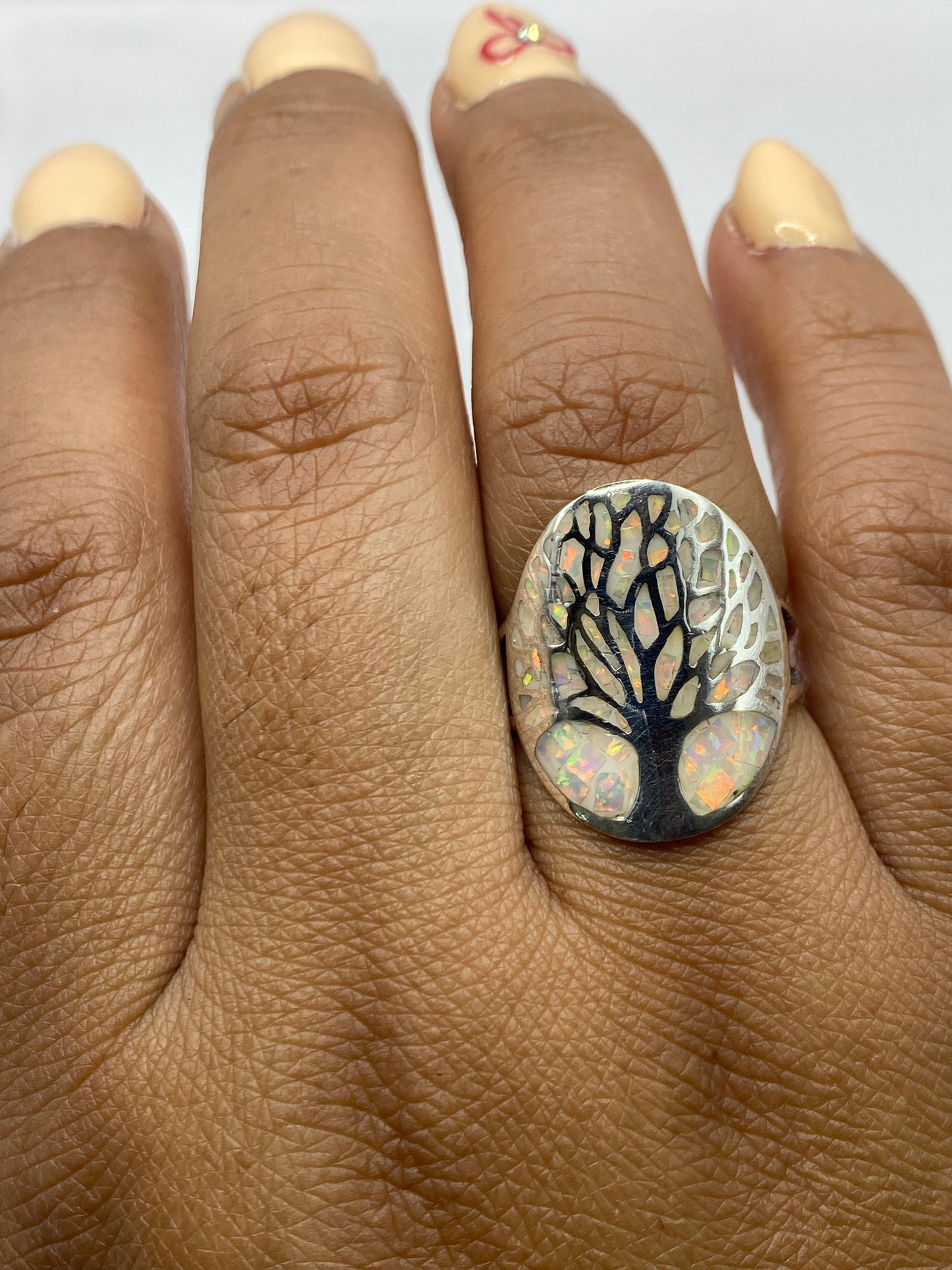 Anillo sobre fondo blanco con el árbol grabado en el Ópalo