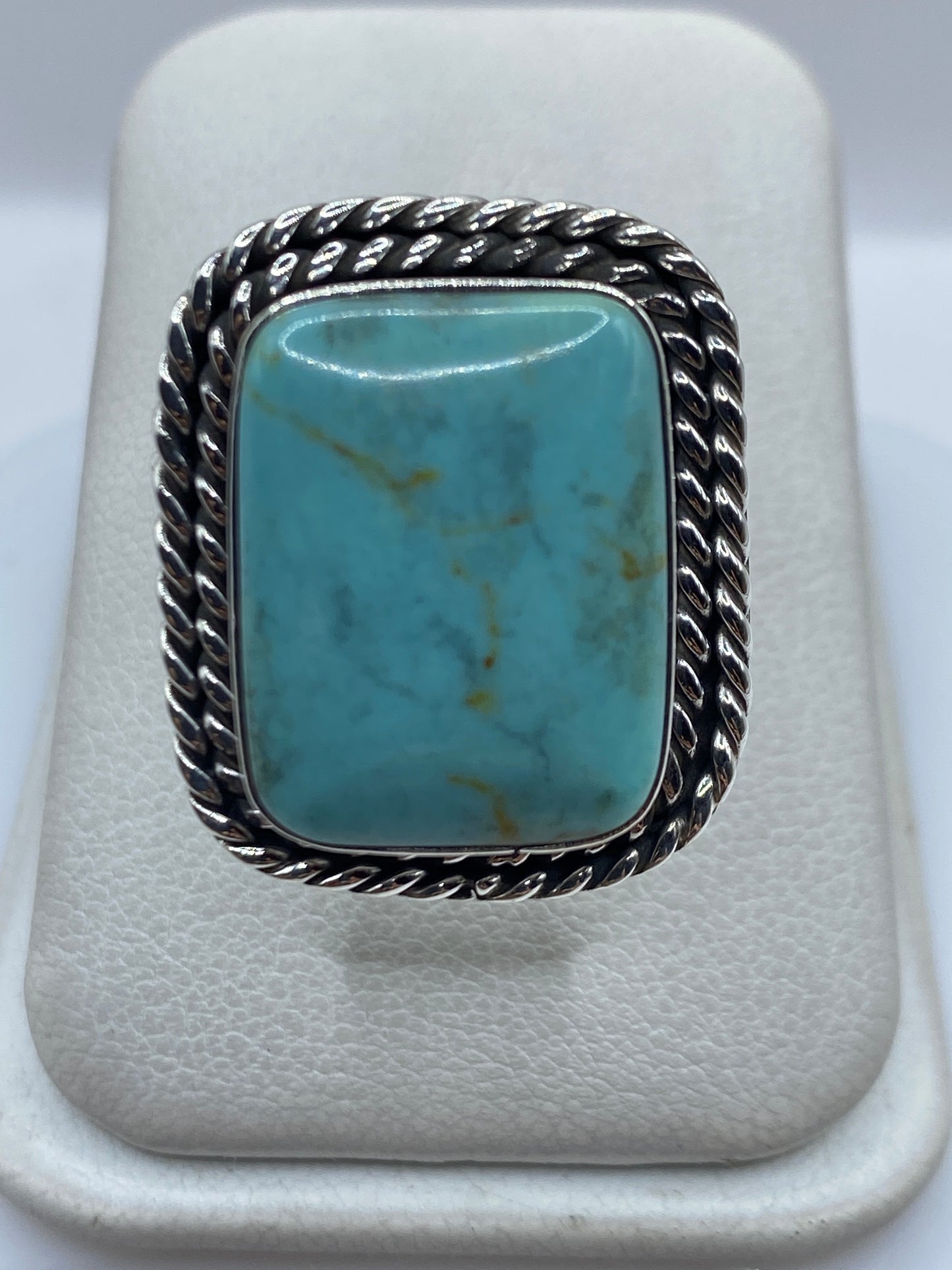 Anillo de plata con turquesa azul cielo engastada, marco retorcido artesanal, vista frontal