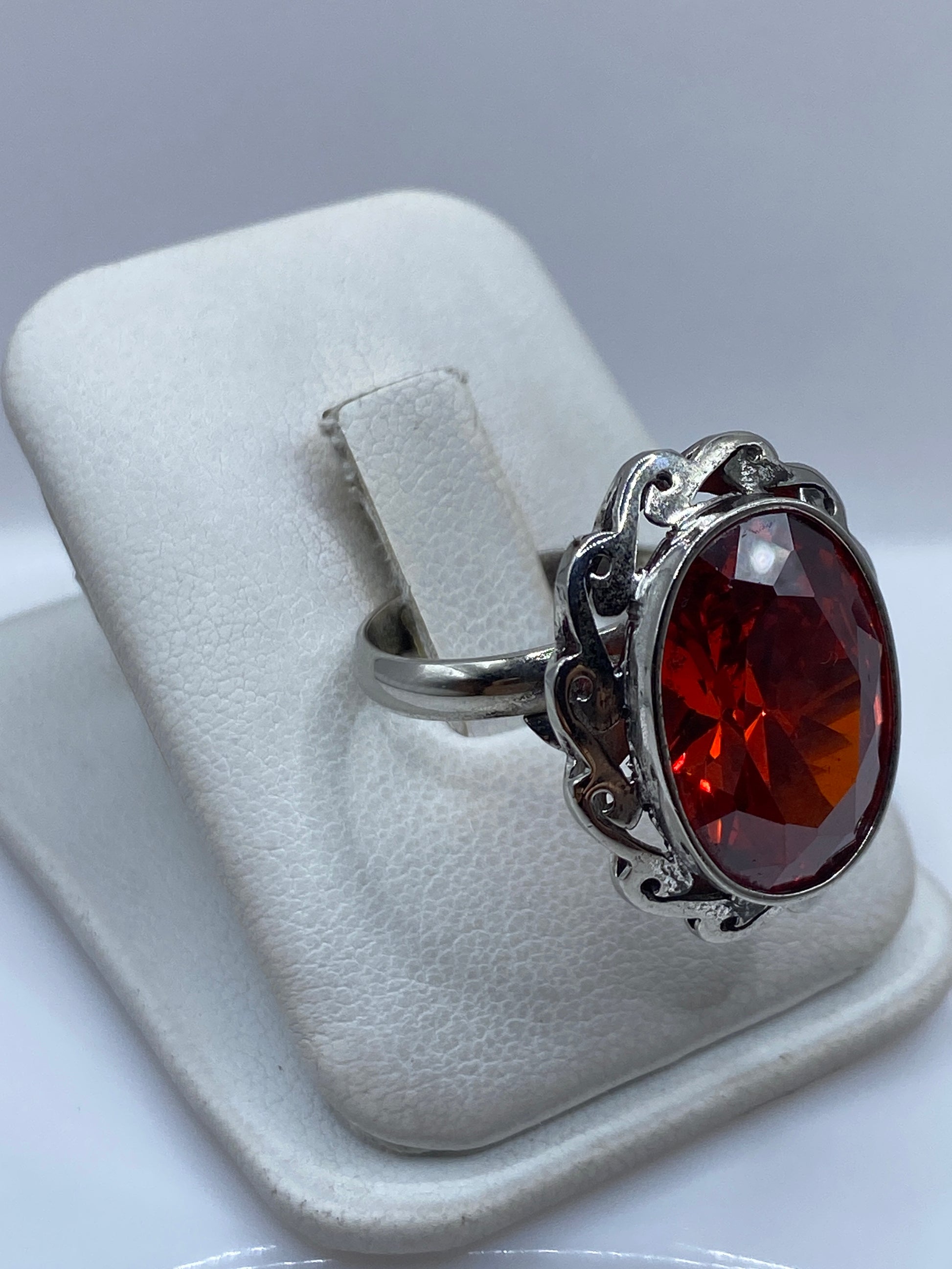 Vista lateral del anillo de plata .925 con circonia roja facetada en estuche