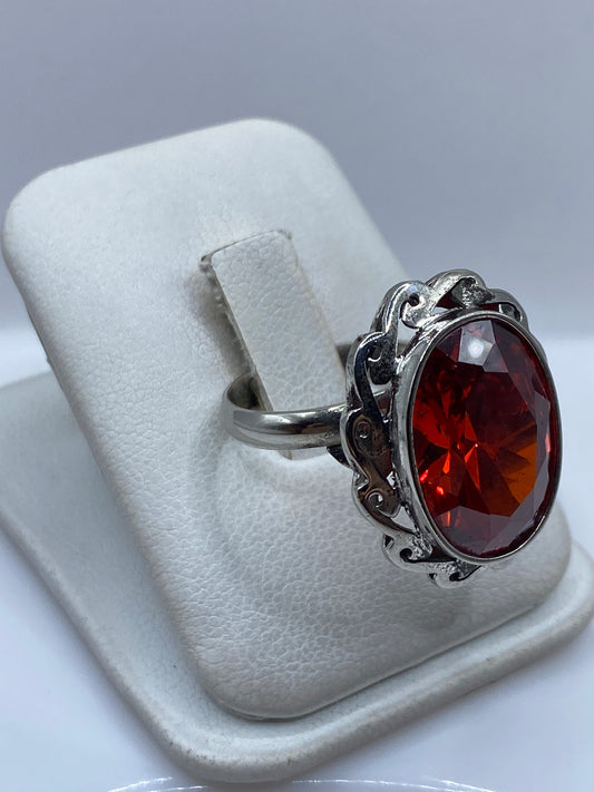 Vista lateral del anillo de plata .925 con circonia roja facetada en estuche