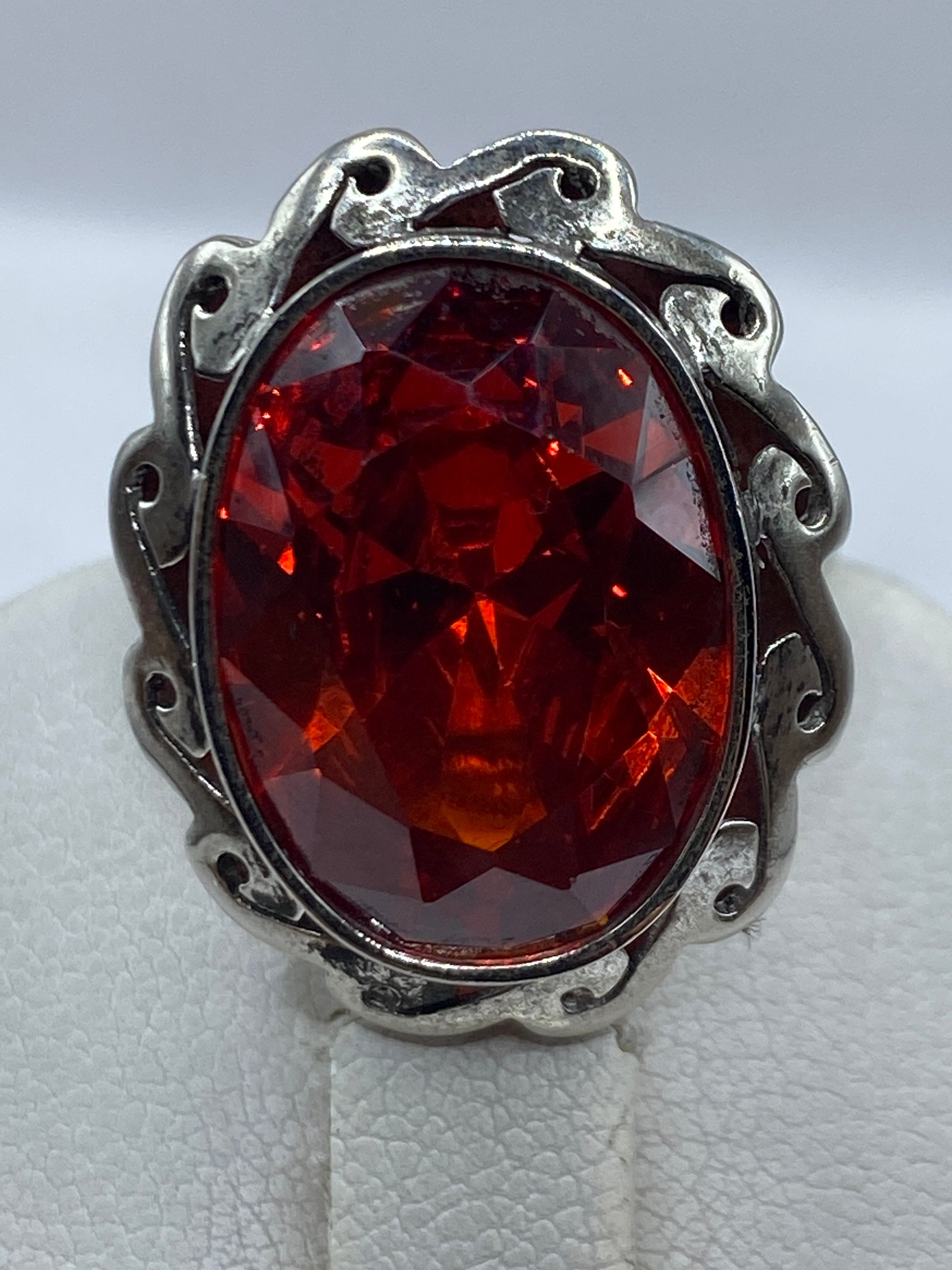 Detalle del engaste y la circonia roja brillante, anillo sobre fondo blanco