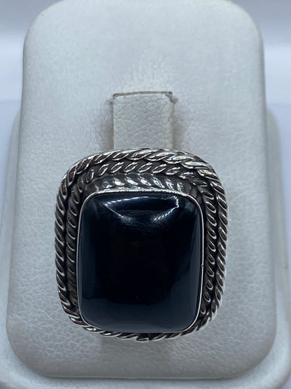 Anillo de plata .925 con ónix negro y marco retorcido, en estuche de presentación