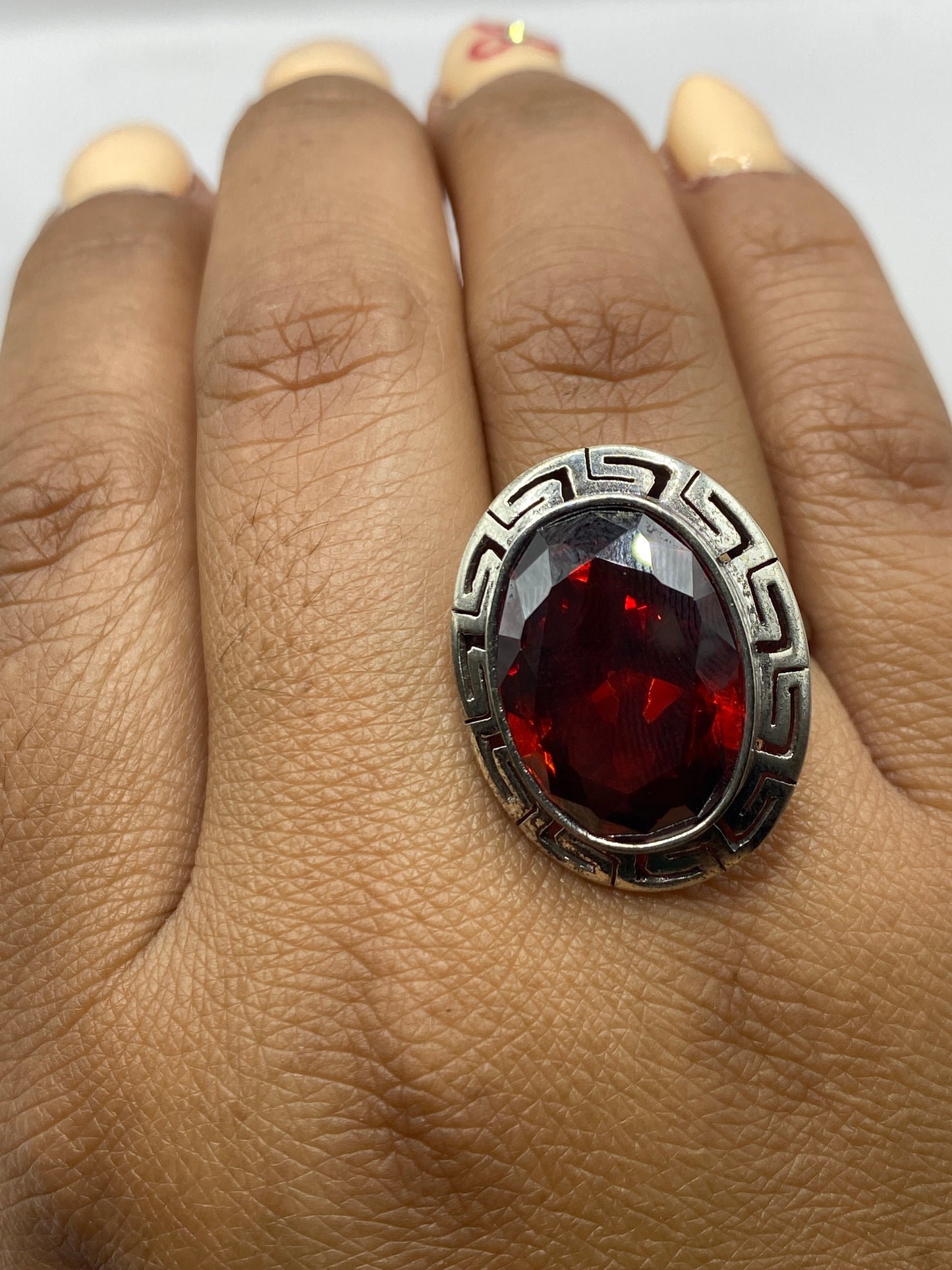 Anillo de circonia roja en mano, diseño prehispánico visible desde arriba
