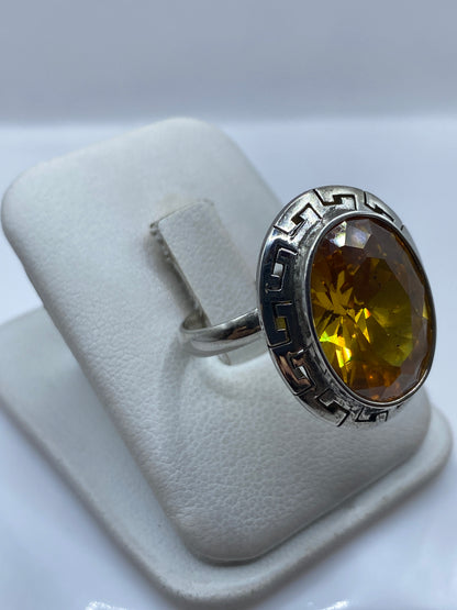 Anillo en la mano mostrando el diseño prehispánico grabado y el brillo de la circonia
