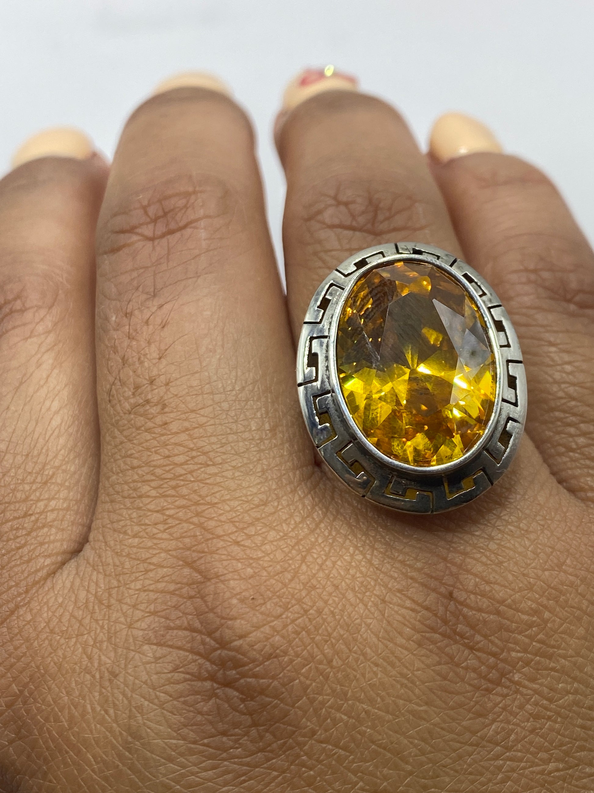 Anillo sobre fondo gris mostrando la talla ajustable y el acabado espejo