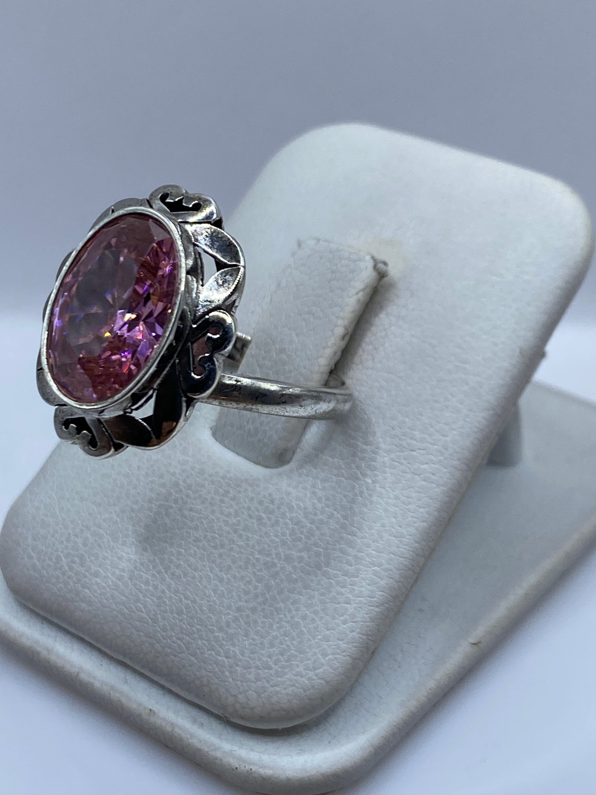 Anillo de plata con circonia rosa en el dedo, mostrando el brillo de la piedra