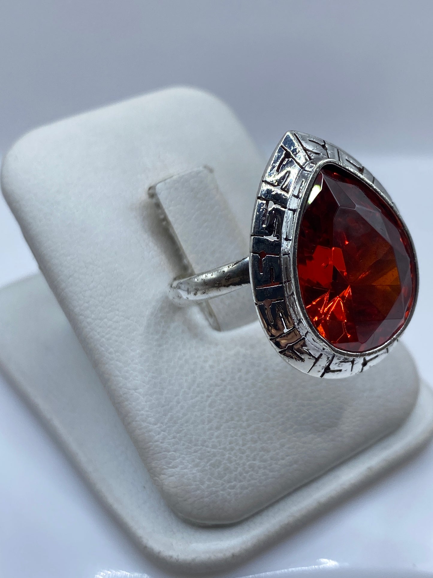 Vista lateral del anillo de plata con circonia roja y aro ajustable