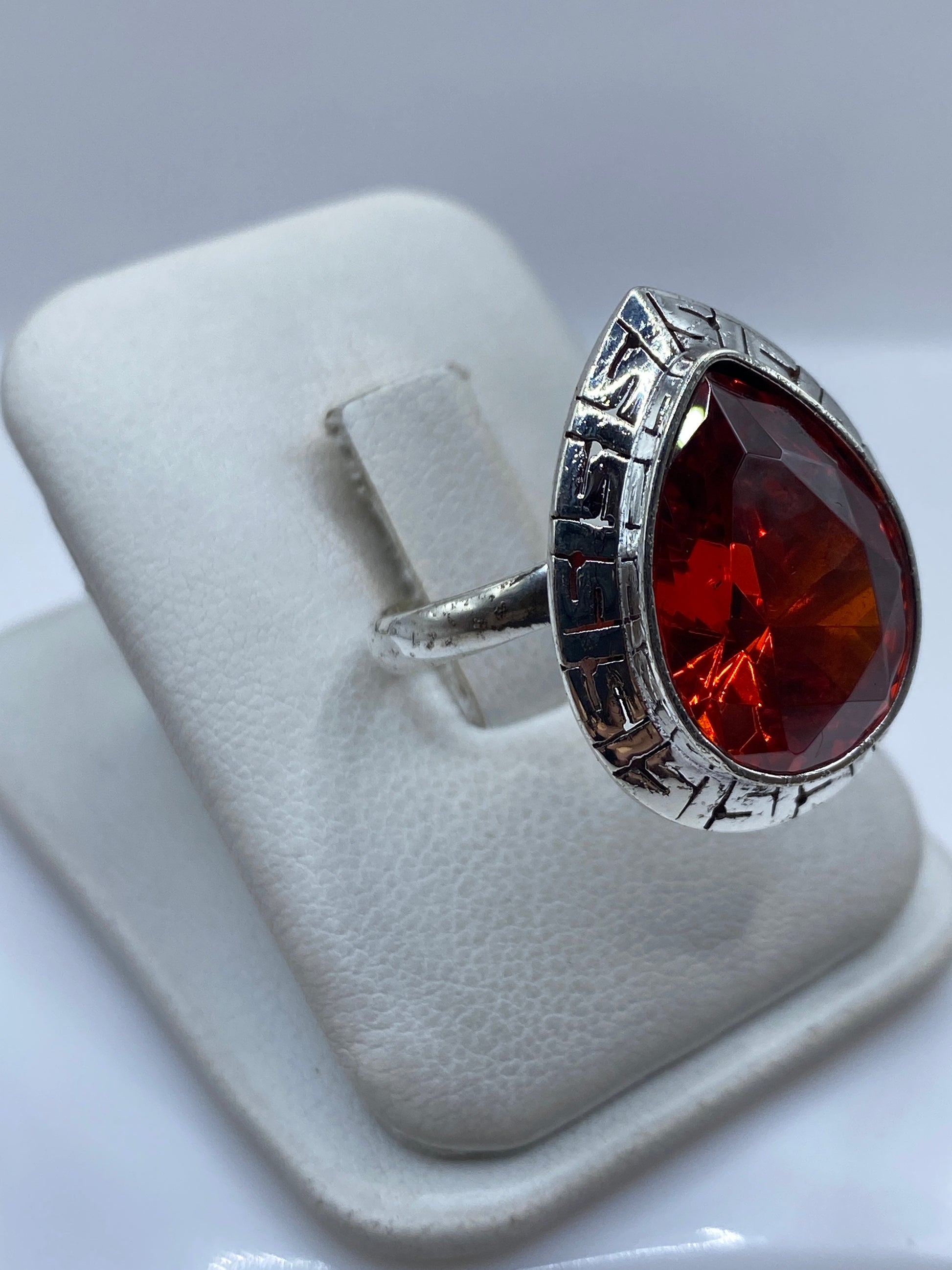 Vista lateral del anillo de plata con circonia roja y aro ajustable
