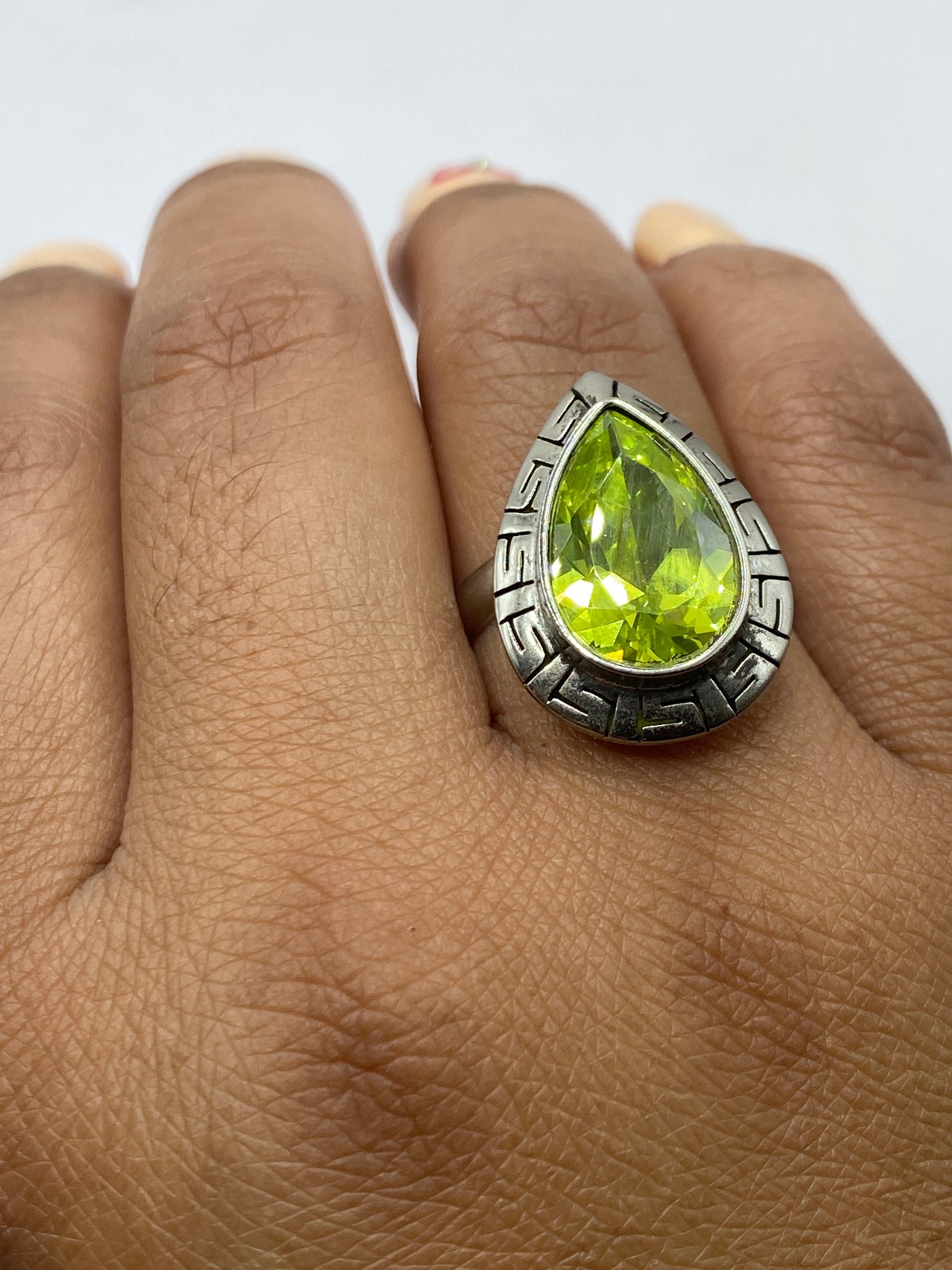 Anillo en dedo: circonia verde brillante mostrando reflejos de luz