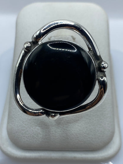 Anillo de plata ajustable con ónix negro pulido en la mano de una mujer