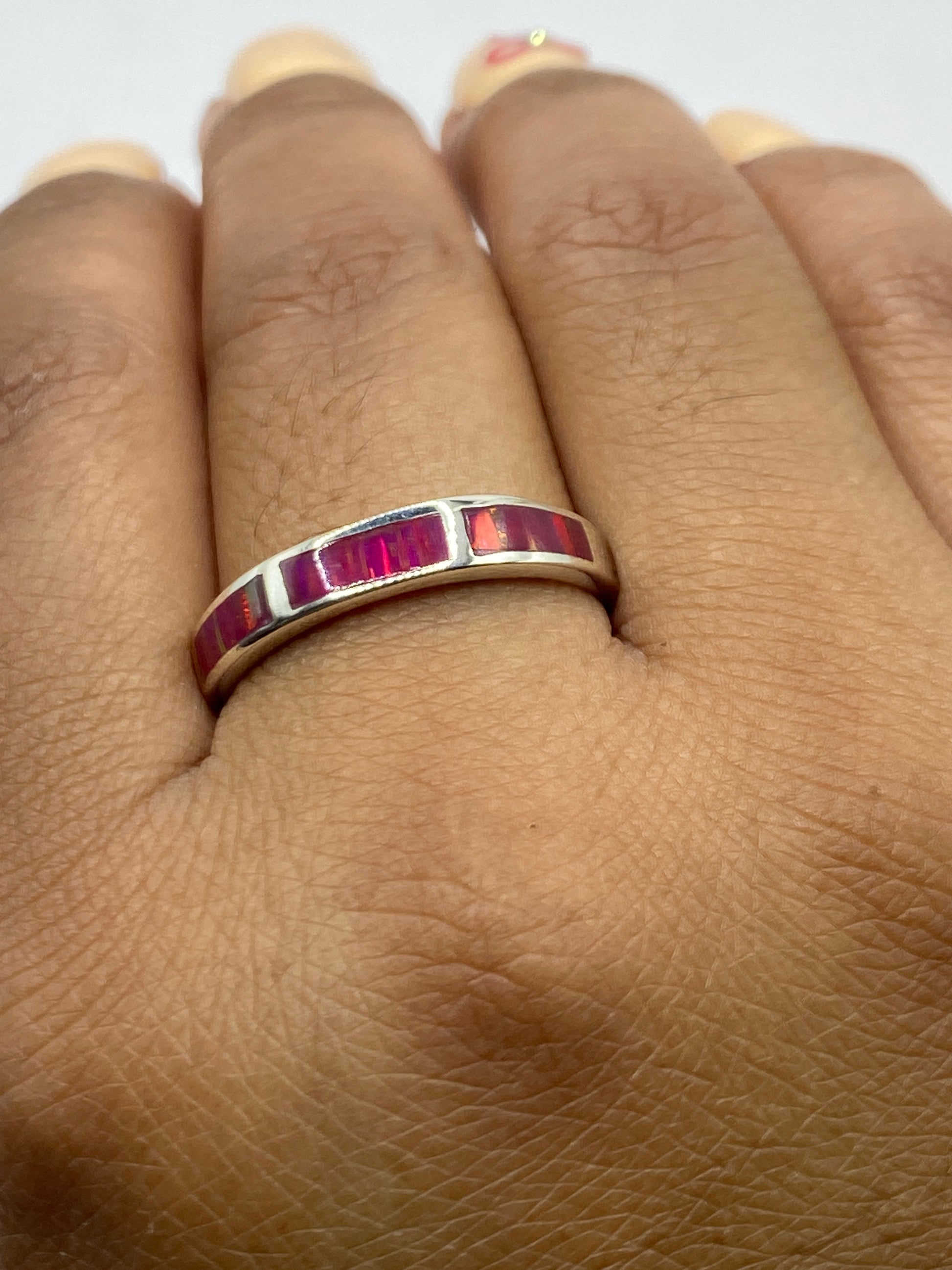Anillo en la mano mostrando cómo brilla el ópalo de fuego rosa