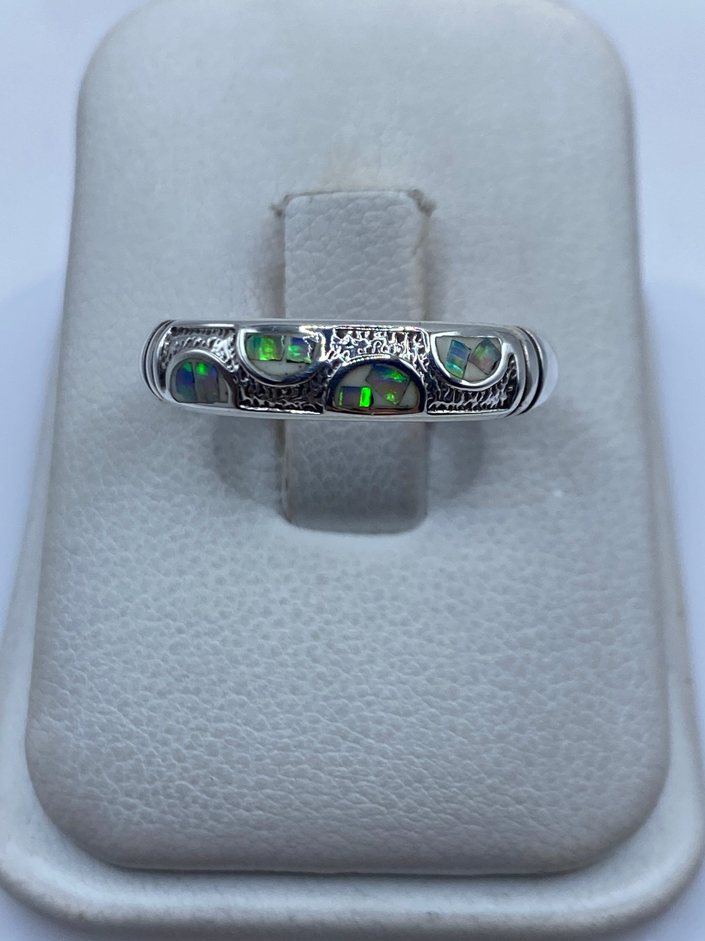 Anillo de plata .950 con ópalo de fuego en tono naranja y azul sobre algodón blanco